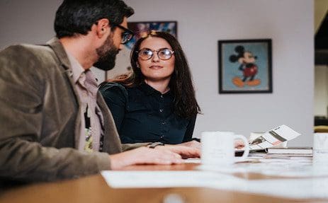Colleagues discussing work at a table