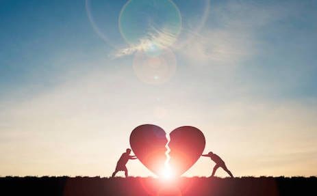 Two figures moving giant heart halves