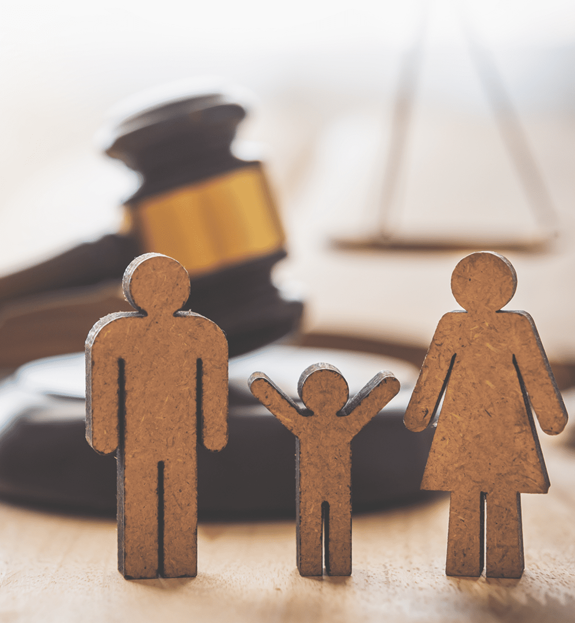 Wooden family figures with judge's gavel background.